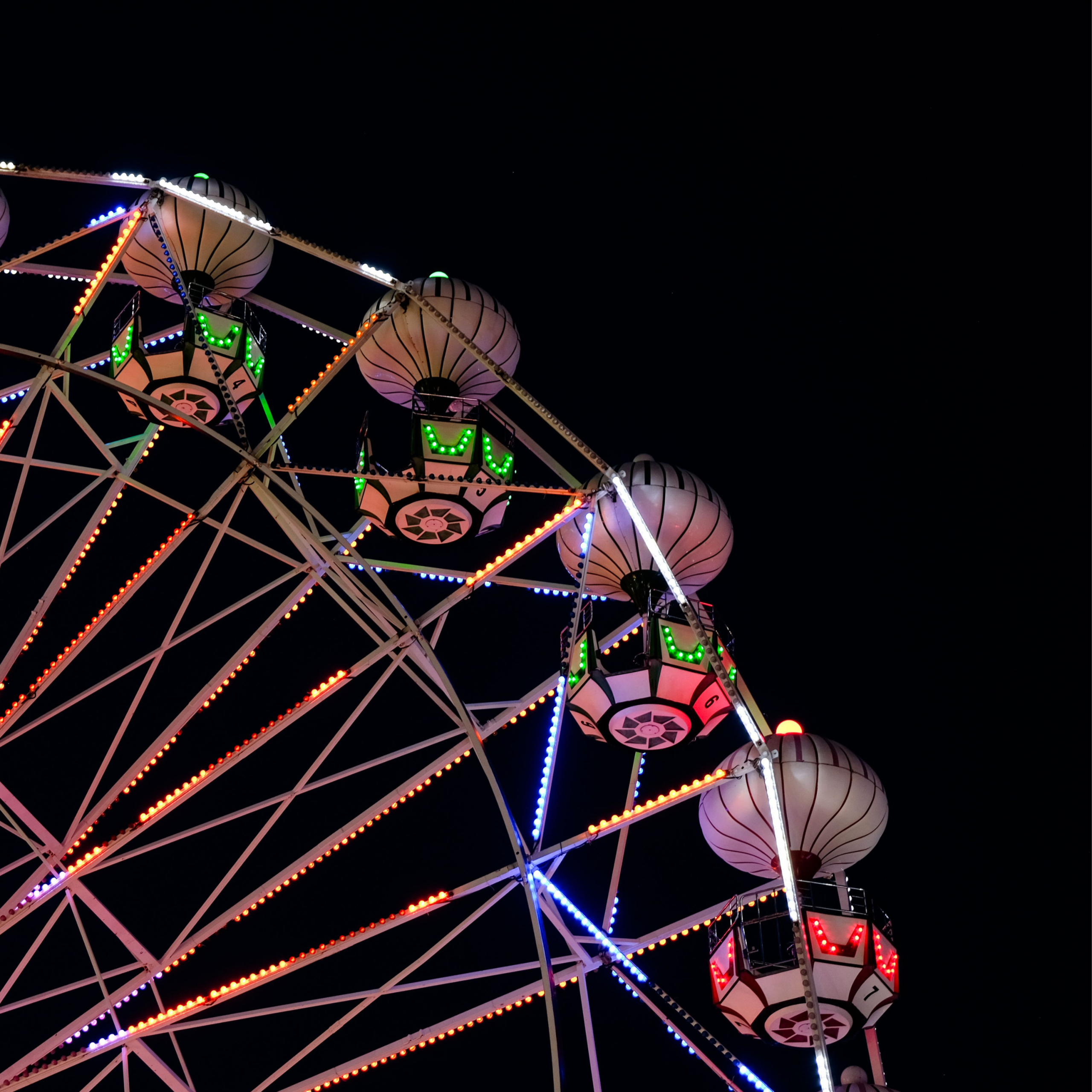 A lit up ferris wheel at night time.